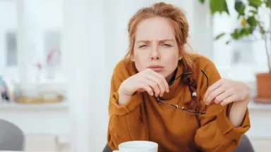 Женщина щуриться и смотрит вдаль